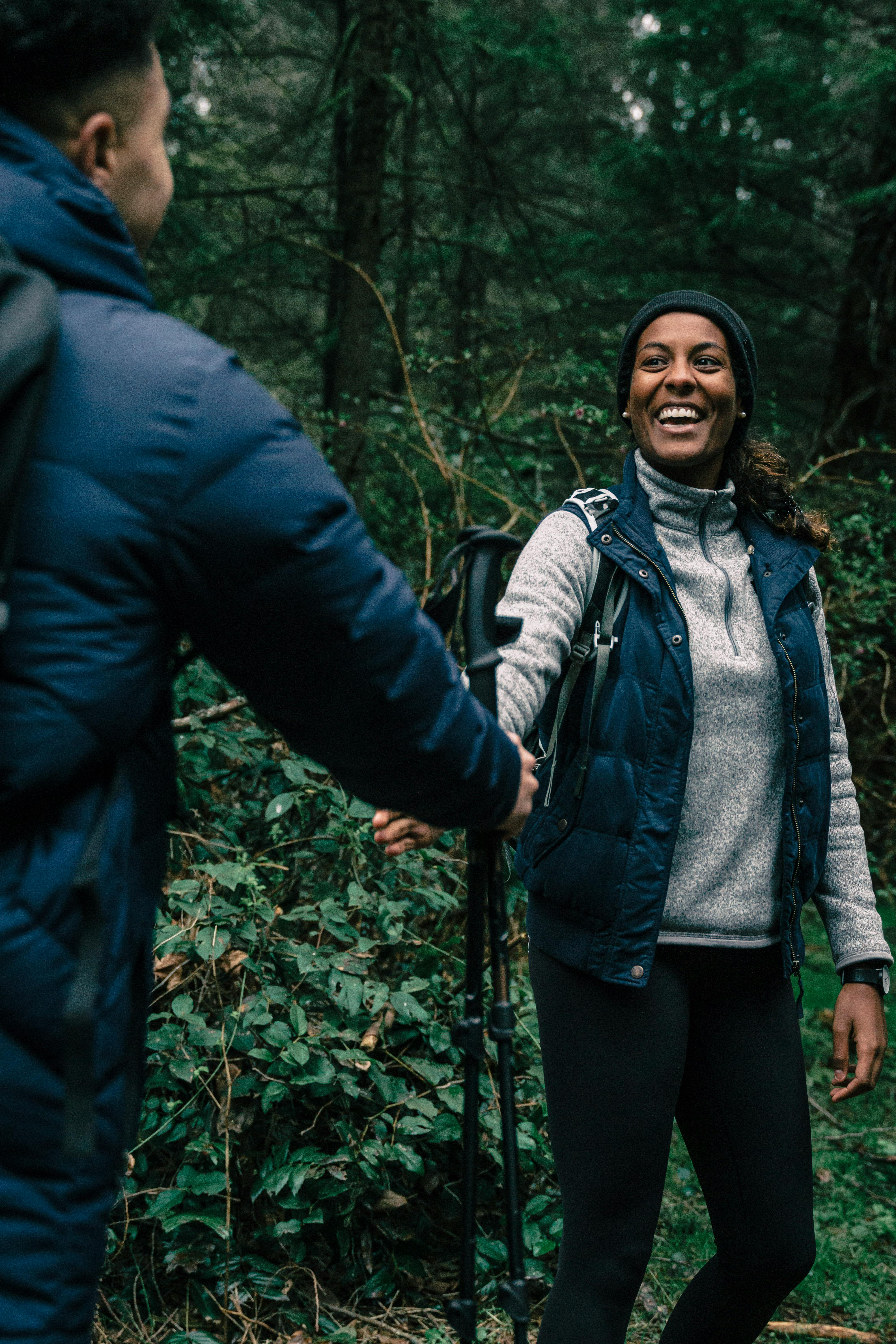 A Woman Smiling while Hiking in a Forest · Free Stock Photo