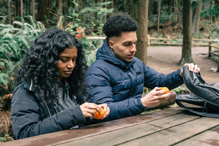 Man And Woman Eating Oranges