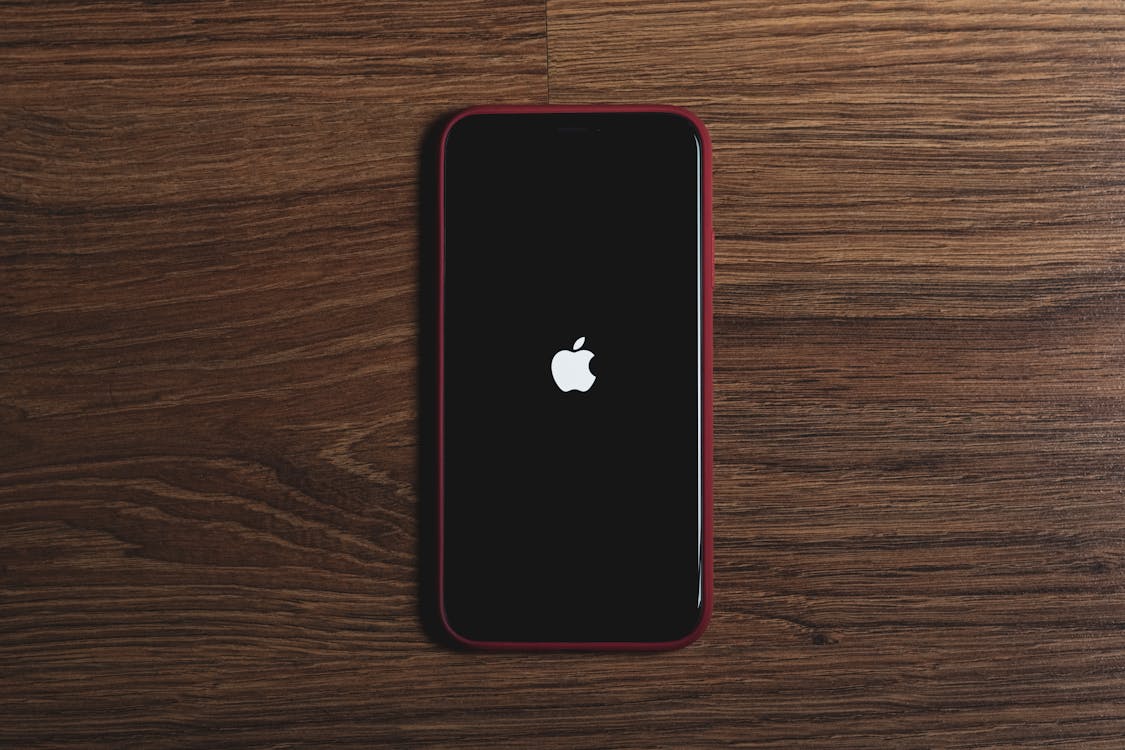 Free Close-Up Shot of an Iphone on a Wooden Surface Stock Photo