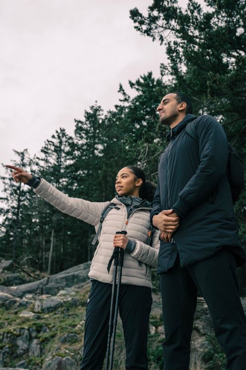 Free Two hikers enjoying a trek through a forested mountain trail. Stock Photo