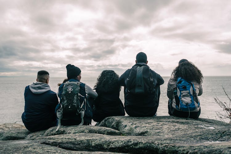 People Sitting And Relaxing On A Cliff