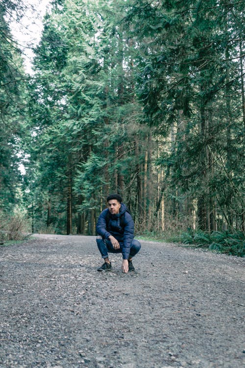 A Man Sitting on a Forest Road