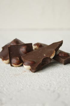 Indulge in a delicious close-up of chocolate nut bark pieces on a textured white surface.