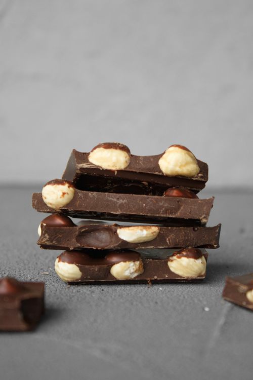 Free Close-up shot of stacked chocolate bars embedded with nuts, highlighting texture and richness. Stock Photo