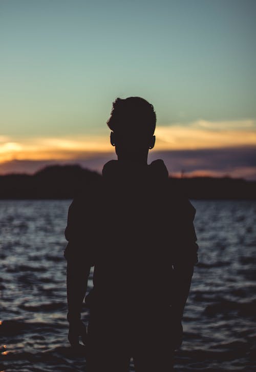 Free Silhouette Photo of Person Near Body of Water Stock Photo