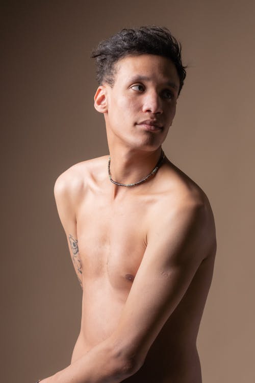 A Shirtless Man Posing in Studio