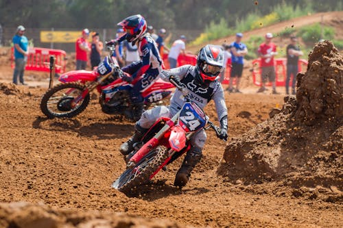 Two Men Riding Dirt Bikes on a Dirt Road