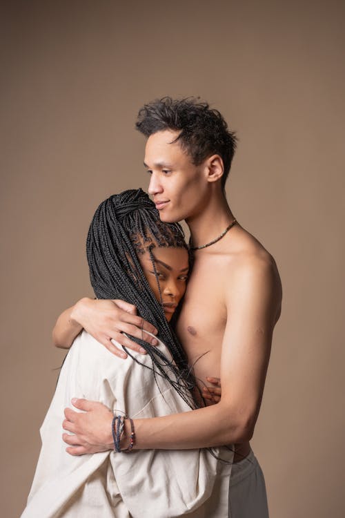 Woman With Dreadlocks And A Shirtless Man Embracing Each Other