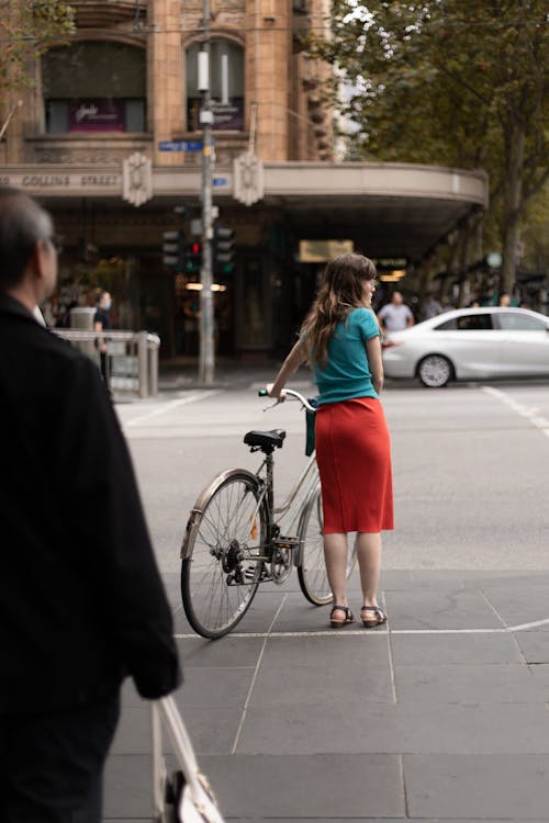 Woman Crossing The Street With A Bicycle