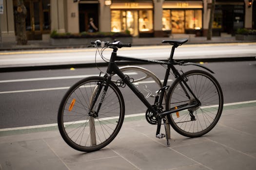 A modern road bike parked beside a busy city street on a smooth sidewalk.