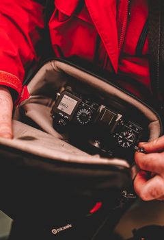 A DSLR camera is snugly placed inside a padded camera bag, ready for travel photography.