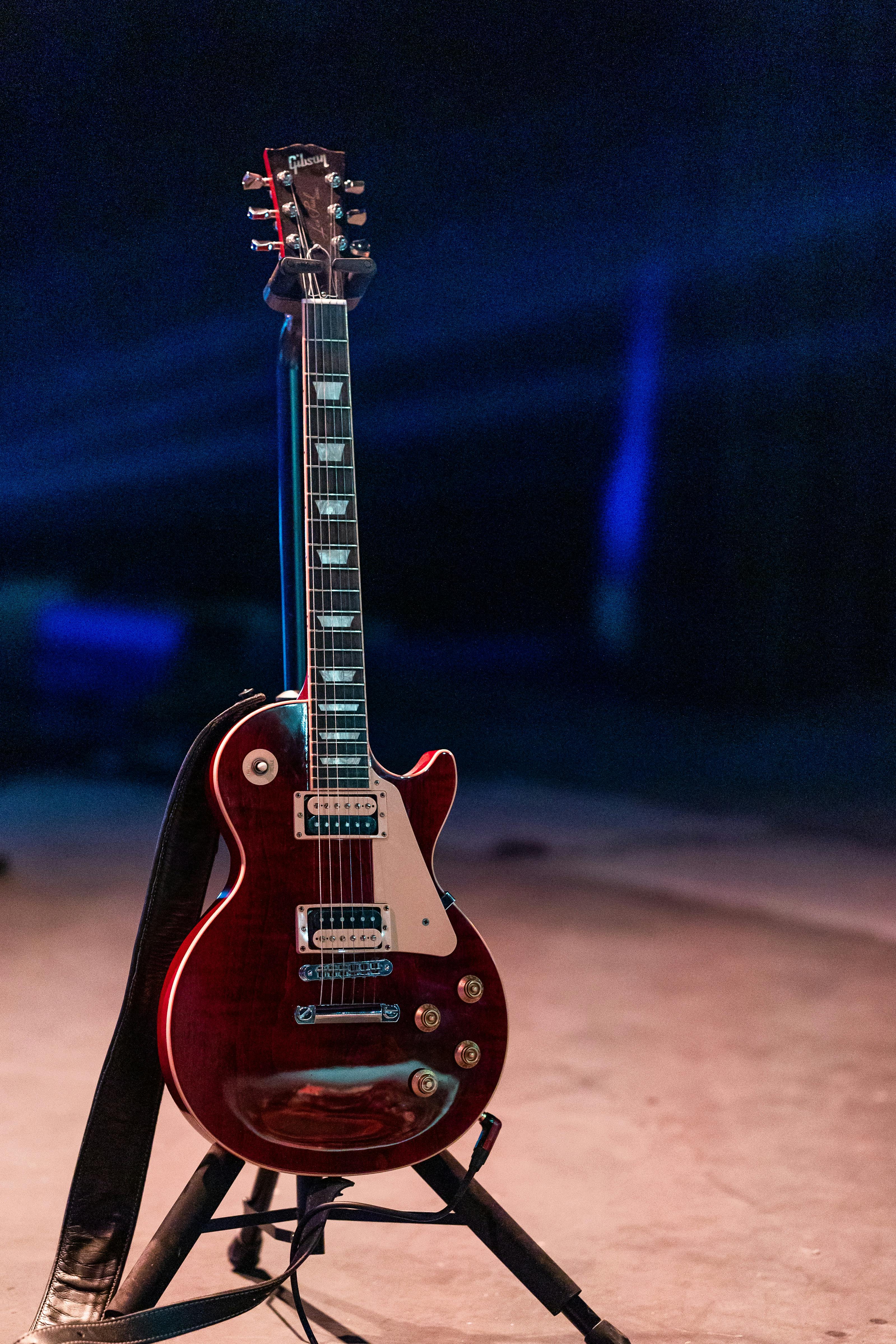 Modern electric guitar on stage against spotlight · Free Stock Photo