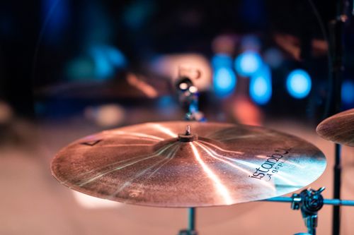Free Cymbals with shiny surface and bell in center on stage with artificial lights on blurred background Stock Photo