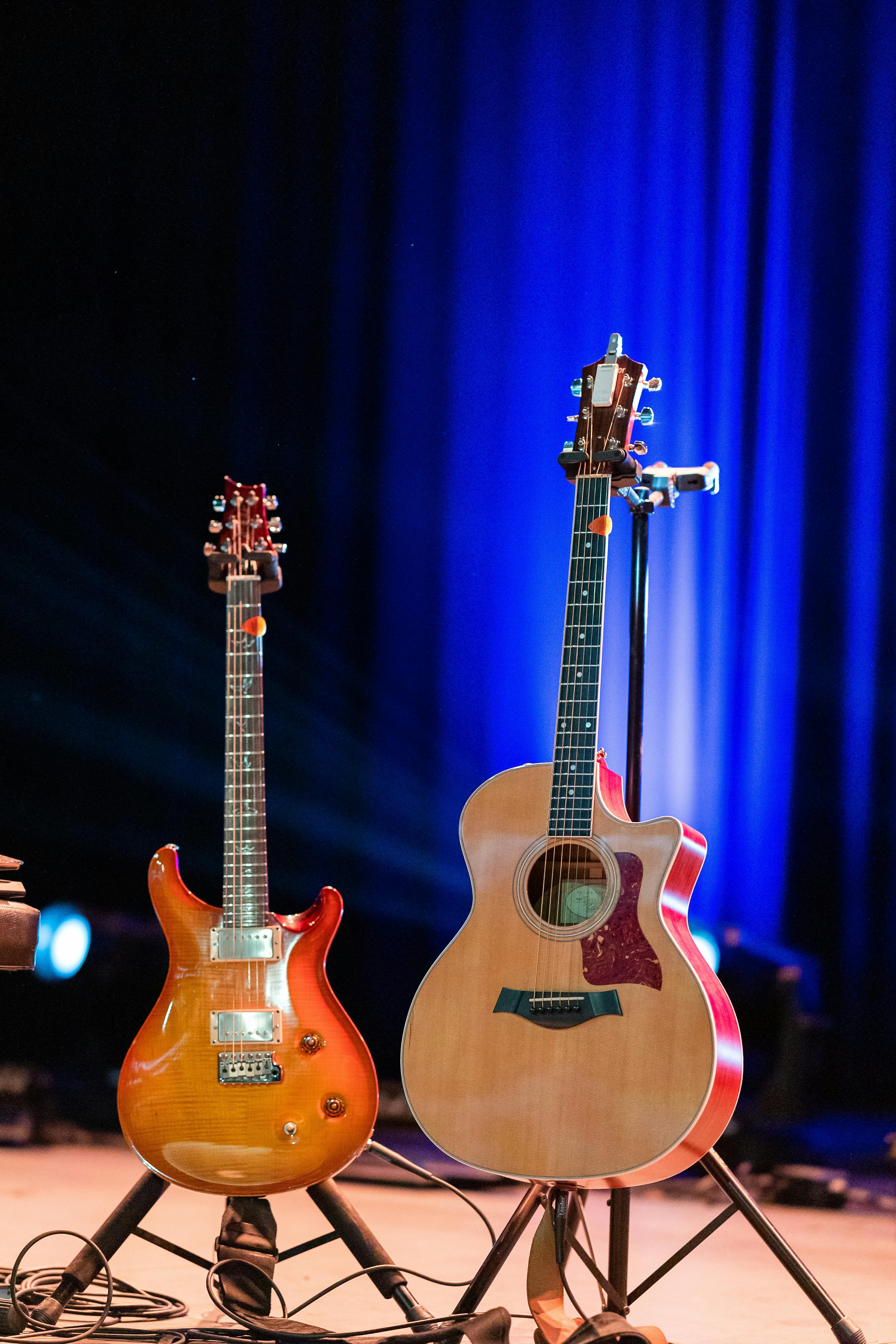 guitars on stage against blue curtains