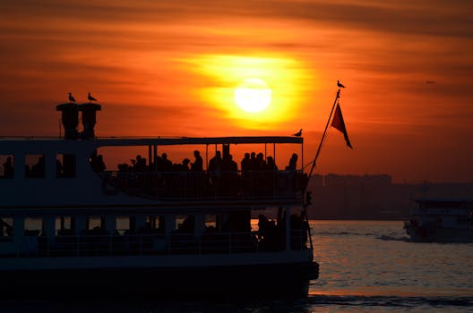 A scenic silhouette of a boat with passengers against a vibrant sunset, creating a dramatic effect.