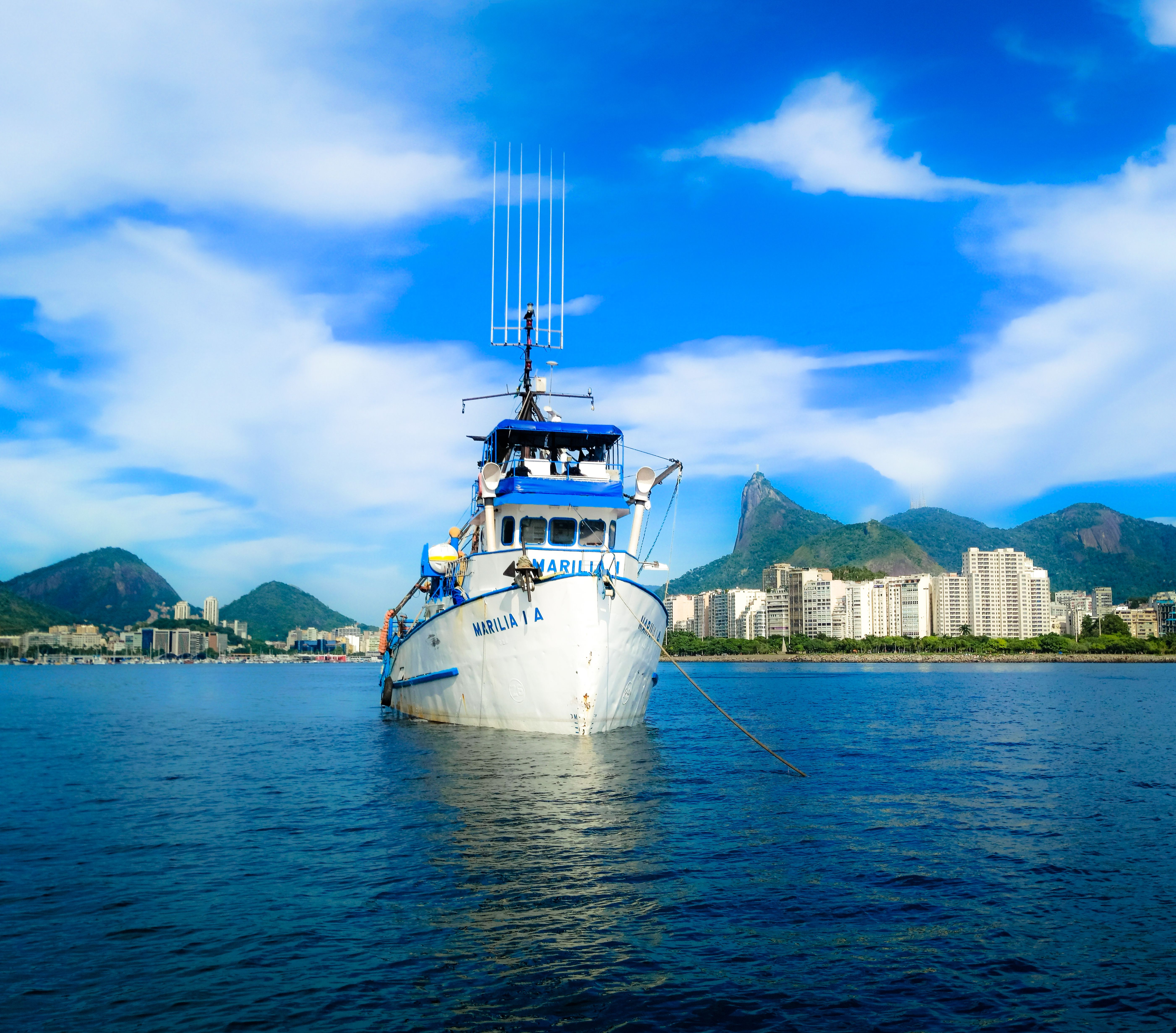 Fishing boat Marilia A anchored off Rio de Janeiro with a scenic cityscape backdrop.