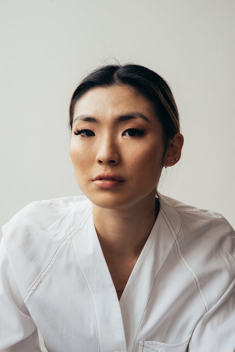 Confident Asian Woman With Brown Eyes In Studio