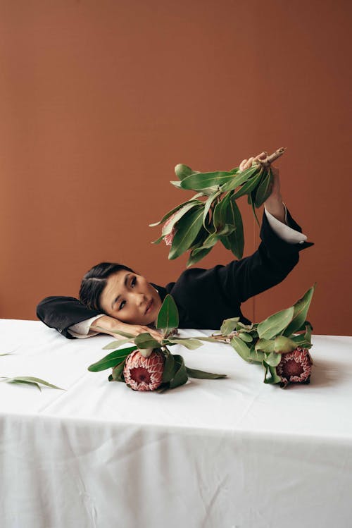 Elegant Asian woman with flowers on table