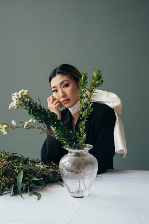 Asian woman at table with fresh verdant branches