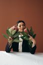 Elegant Asian woman smelling pink exotic Protea flowers