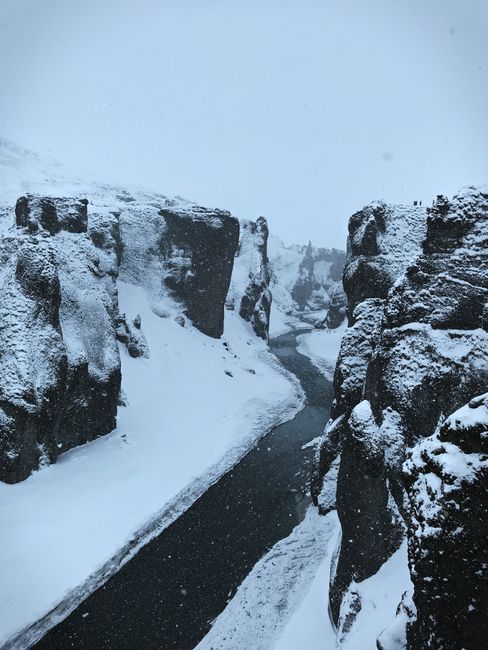 Breathtaking winter scene of a snow-covered canyon and river in Iceland.