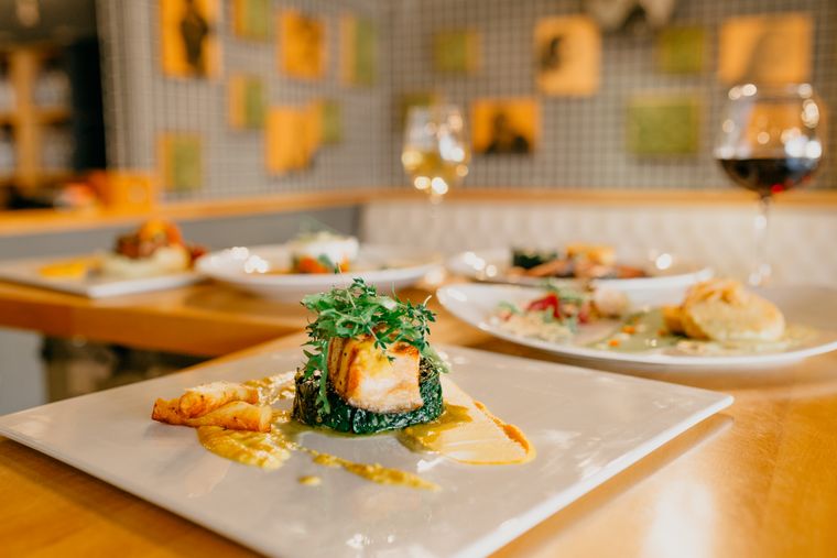 Assorted plates served on a wooden table in a bright dining room — photo by Taha Samet Arslan on Pexels
