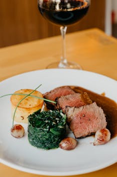 A delectable beef steak with wine, spinach, and potatoes, perfect for fine dining.
