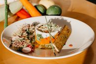 Delicious veggie dish with crispy bread on table in kitchen