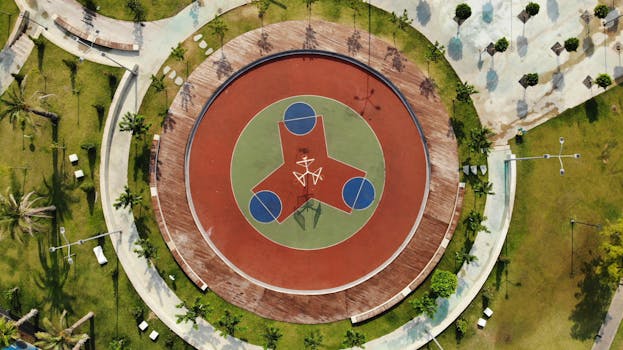 Drone shot of a unique basketball court design surrounded by greenery in Antalya, Turkey.