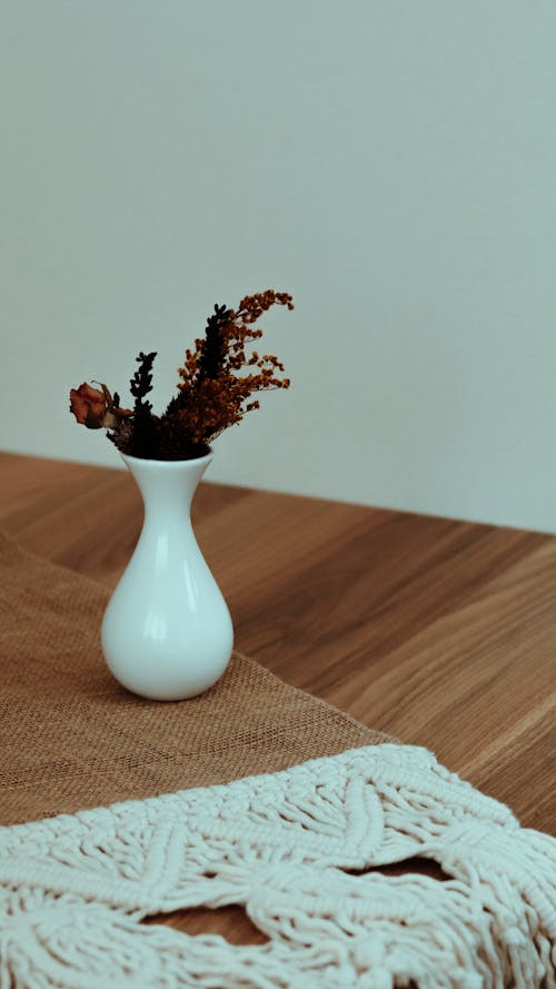 Vase with dry flowers on carpet on laminate of home