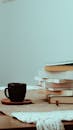 Cup of coffee near pile of books at home