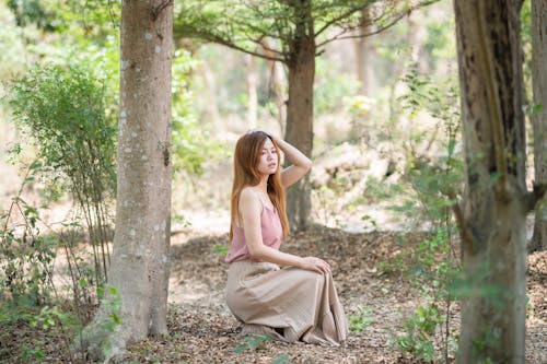 Woman Crouching between Trees