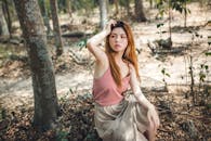 A Woman in Pink Top Sitting Near a Tree