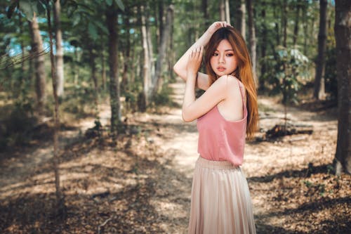 A Young Woman Posing while Standing on Forest