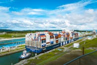 Blue and White Cargo Ship on Dock Under Blue and White Cloudy Sky