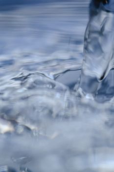 Blurred close-up of flowing water, showing dynamic movement and abstract forms.