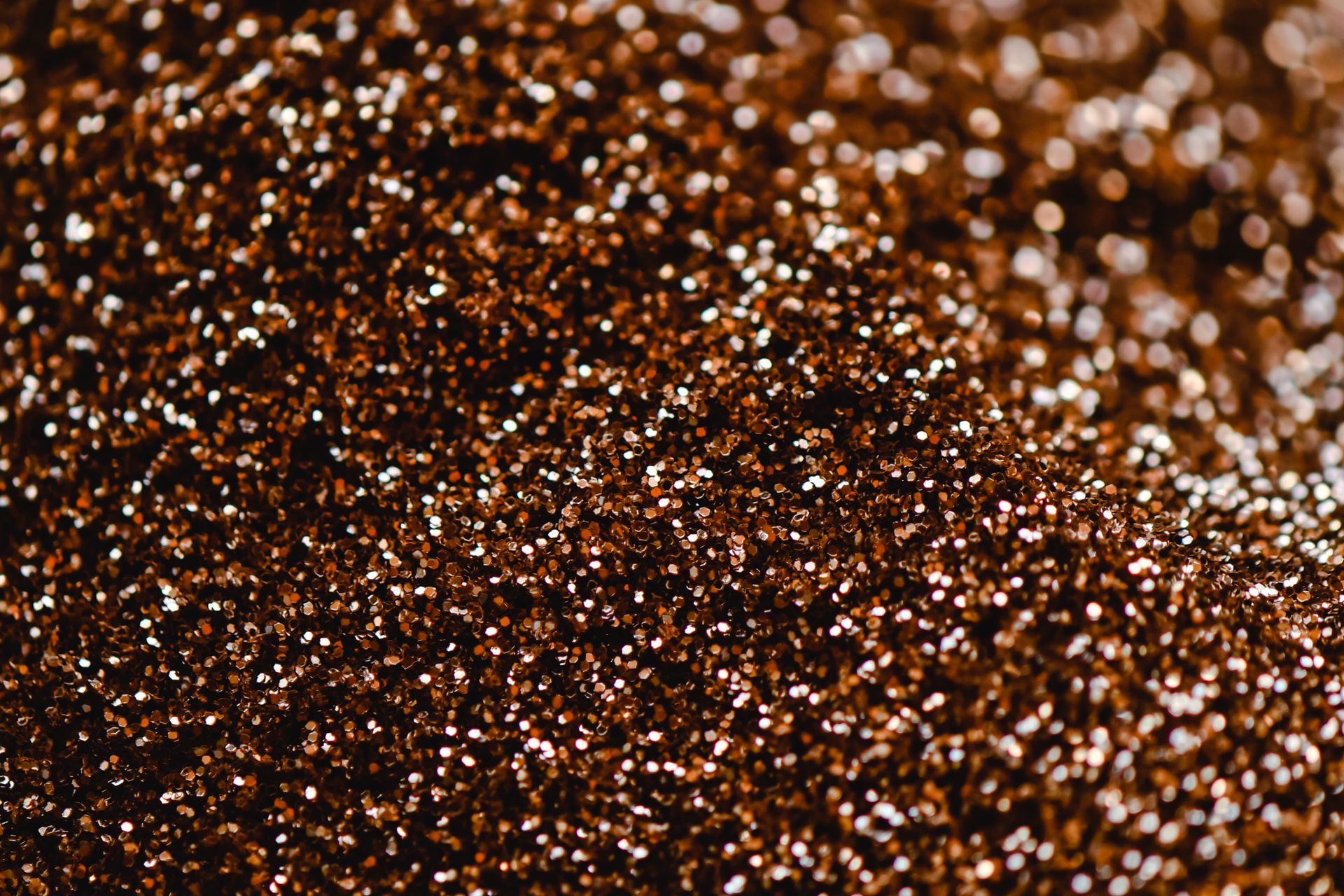 High-resolution close-up image capturing the shiny and sparkly texture of bronze glitter.