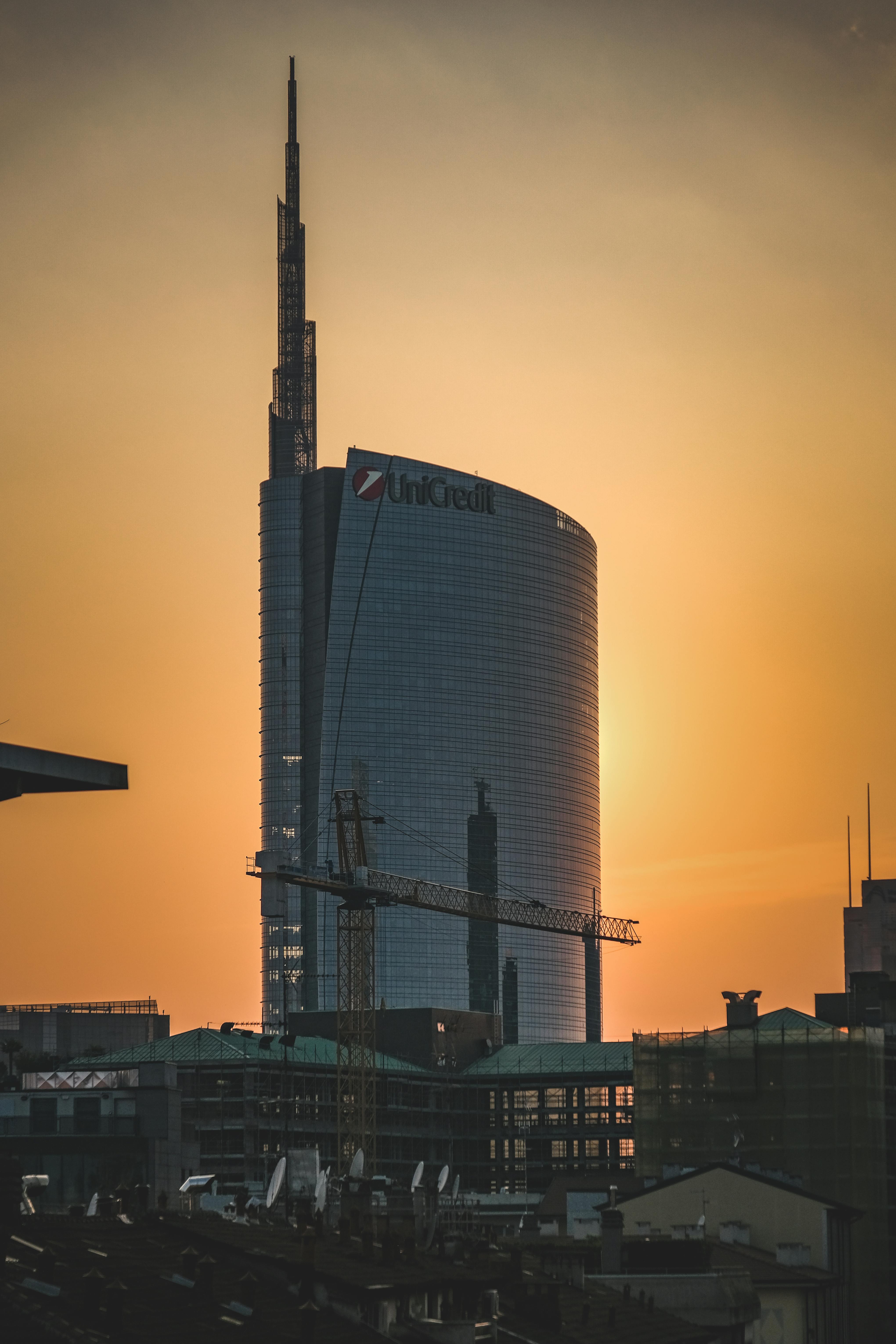 modern skyscraper under construction in sunset