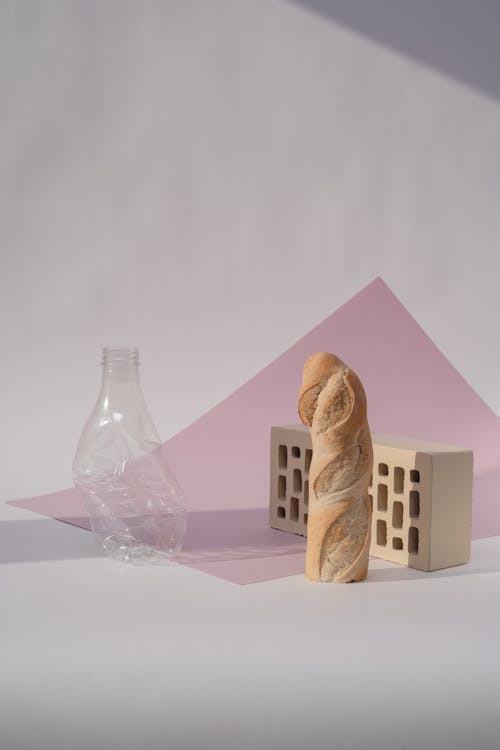 Photo of a Baguette near a Plastic Bottle