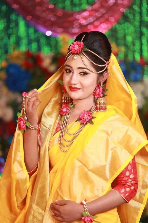 Free Elegant South Asian woman in traditional yellow bridal attire with floral jewelry, showcasing cultural beauty. Stock Photo