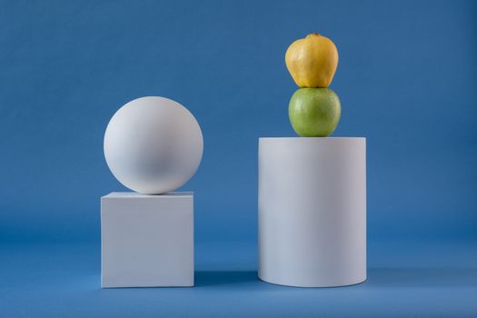 Fruits on the White Cylinder Shape on Blue Background