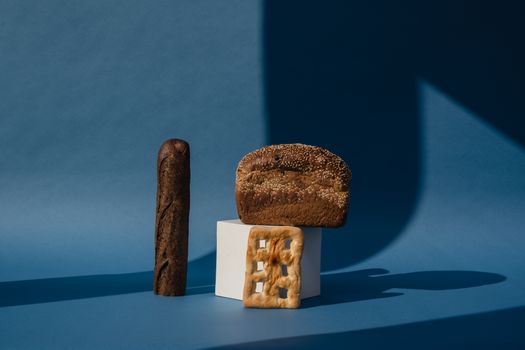 A creative studio shot of different breads against a rich blue backdrop, showcasing texture and light play.