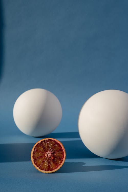 Sliced Orange Fruit Beside the White Balls 