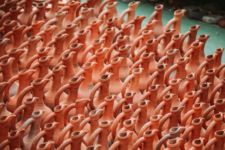 Rows Of Ceramic Vessels With Handles And Spouts