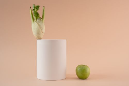 Free A minimalist still life featuring a fennel bulb and green apple against a beige backdrop. Stock Photo
