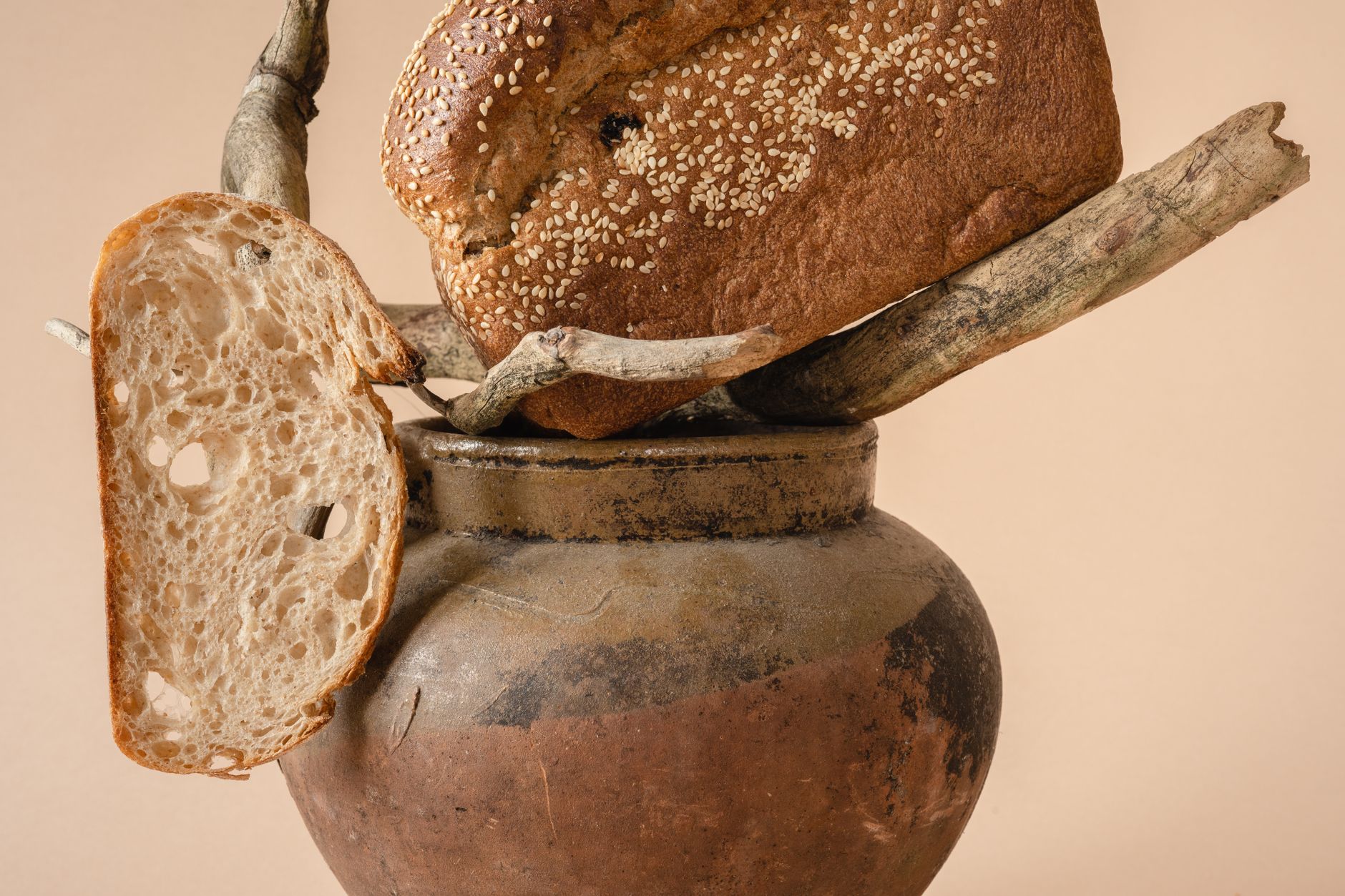 A creative still life arrangement featuring rustic bread and jug with a natural artistic touch.