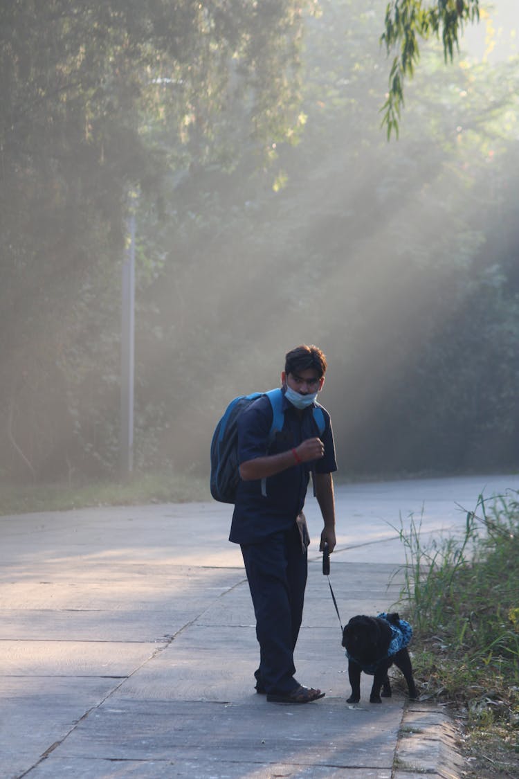 Man Holding The Leash Of A Dog On The Street