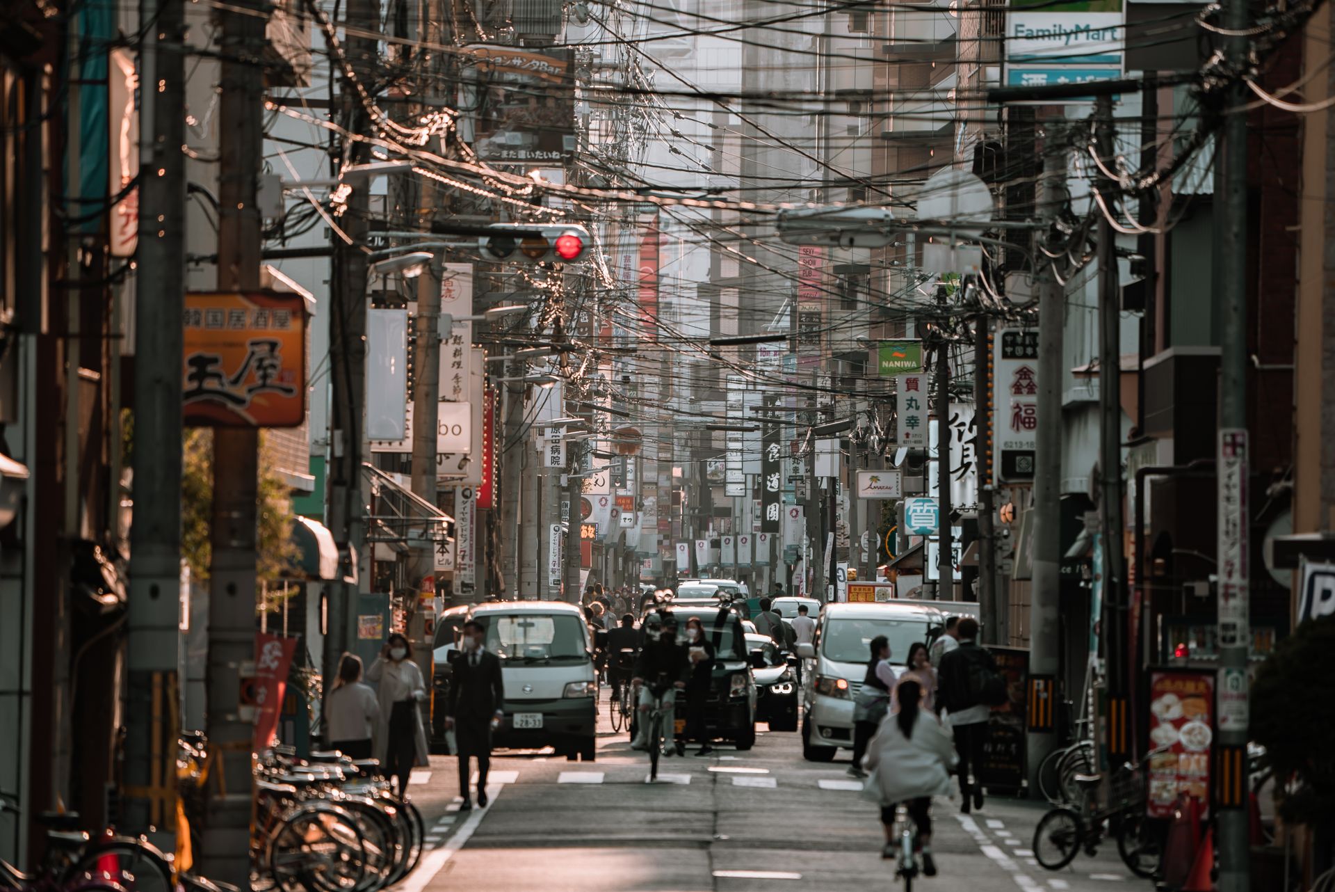 Busy street scene in Osaka, Japan showcasing urban life with people and vehicles.