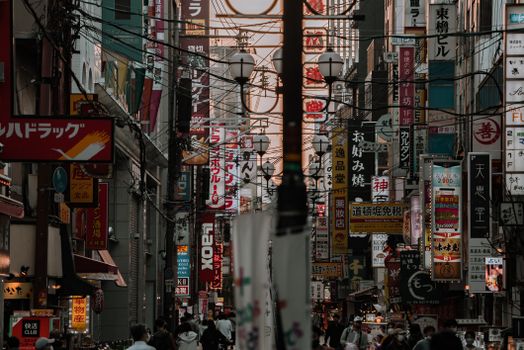 Explore the vibrant urban landscape of Osaka with bustling streets filled with colorful signages.