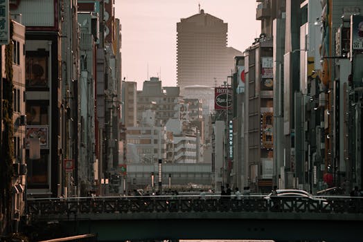 Cityscape of Osaka with urban buildings and bridge at dusk, showcasing Japan's architectural beauty.